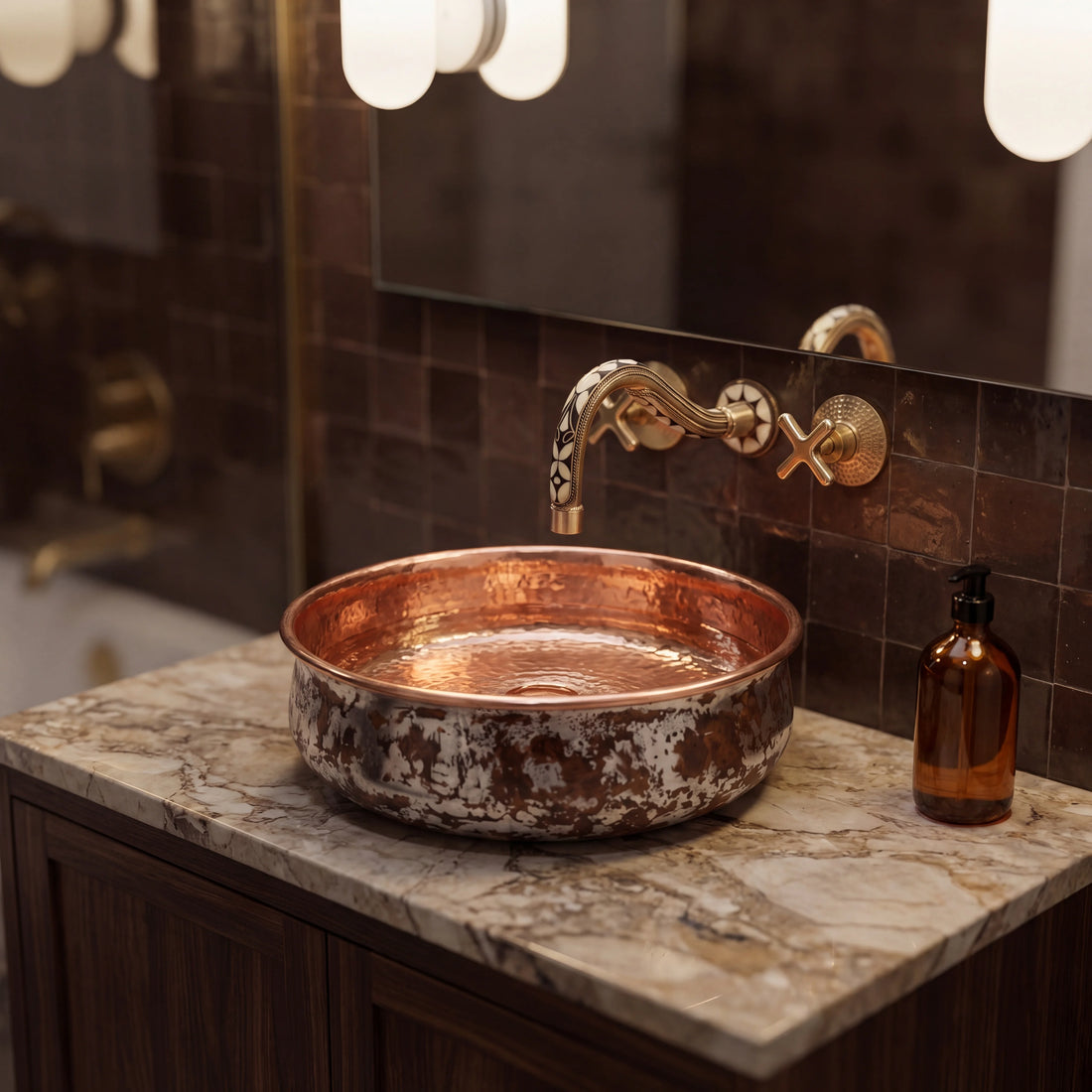 Copper sink with gold faucet on a marble countertop in a bathroom setting.
